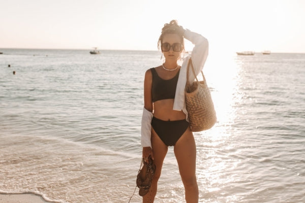 Mulher na praia com bolsa de praia